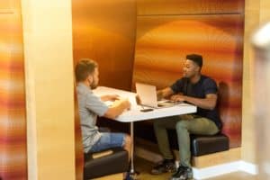 Informal job interview taking place between two men in a relaxed office setting